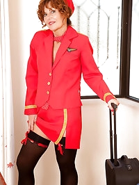 Mature stewardess shows off her tits and spreads her..